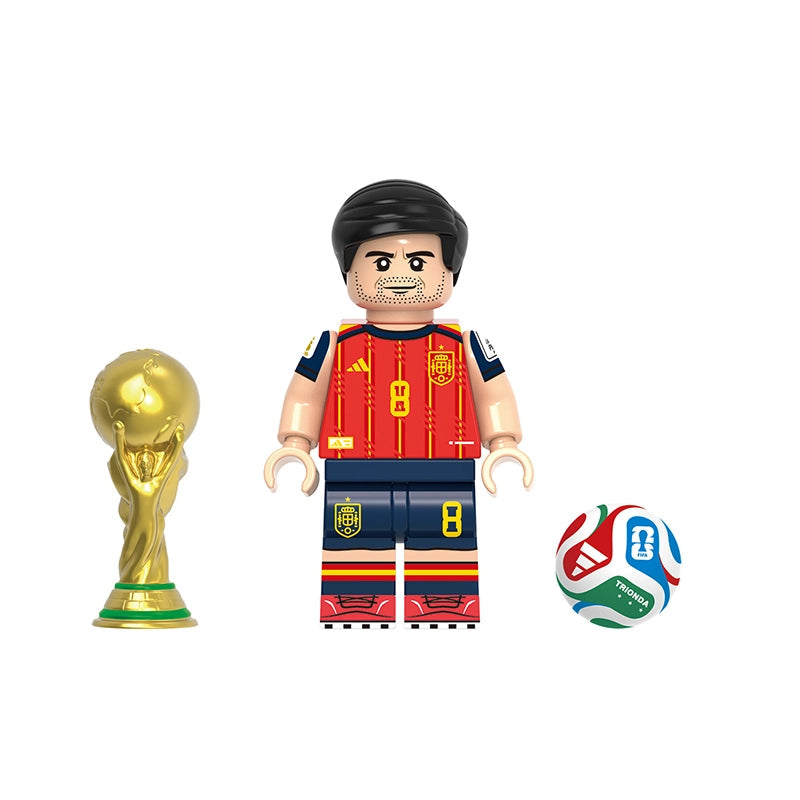A toy soccer player minifigure labeled Fabián, shown with a gold trophy and a soccer ball on a plain white background. The figure wears a red Spain jersey with yellow accents and dark blue shorts.