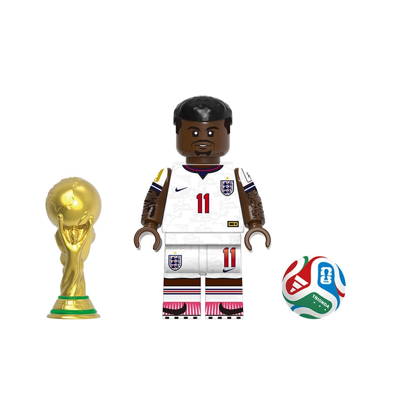 A toy soccer minifigure labeled Rashford stands in the center, flanked by a gold FIFA-style trophy on the left and a multicolored soccer ball on the right. The figure wears a white England jersey with the number 11 and a Nike logo.