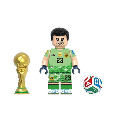 A soccer-themed building block minifigure named Emiliano Martínez, wearing a green Argentina national team goalkeeper jersey and shorts with the number 23. The set includes a gold FIFA World Cup trophy and a red, white, and blue soccer ball, all on a plain white background with the model number GH0810 at the top and the name of the player at the bottom.