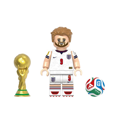 A toy soccer player minifigure labeled 'Kane' with a white England jersey, shown alongside a gold trophy and a multicolor soccer ball on a plain white background. A gray label at the top reads 'GHO823'.
