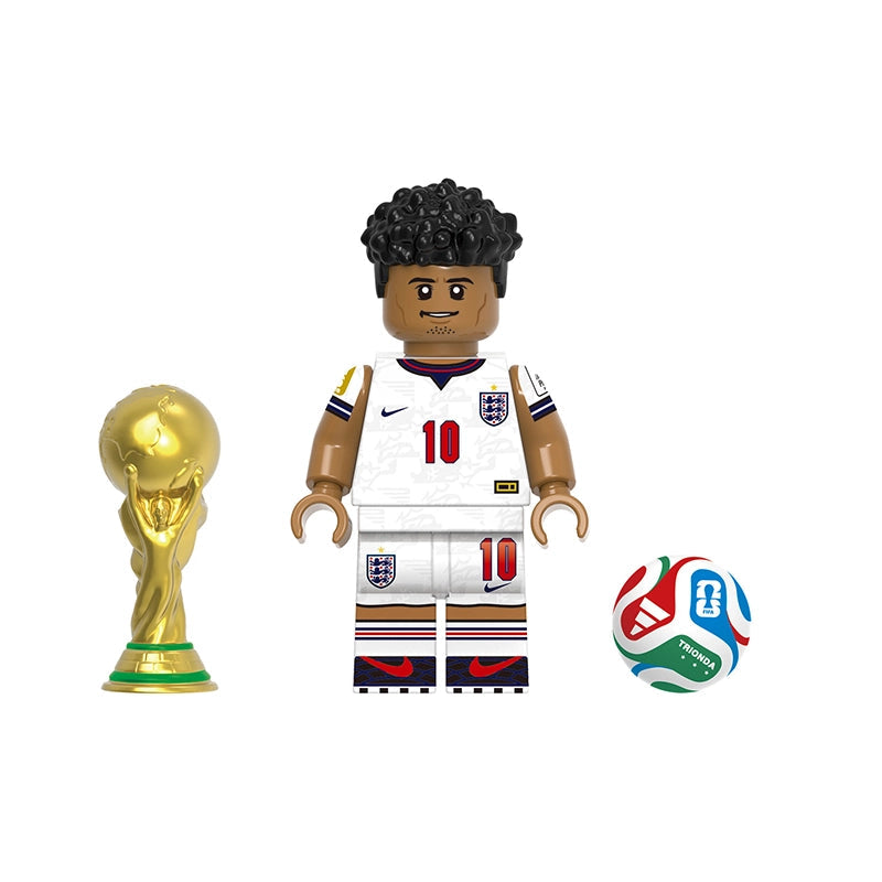 A soccer-themed toy set featuring a Bellingham minifigure in a white England jersey with the number 10, a gold FIFA trophy, and a multicolor soccer ball, shown on a plain white background with model number GH0824.