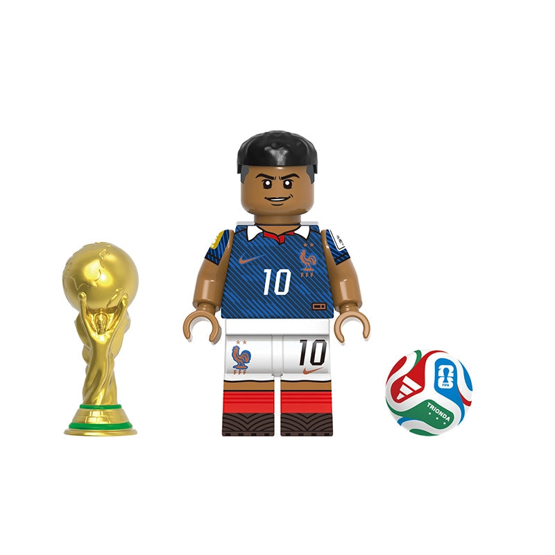 A toy minifigure of Mbappé wearing a blue and white France soccer jersey with the number 10, shown with a gold FIFA trophy and a soccer ball on a white background. The text 'GHO832' and 'Mbappé' are printed on the image.
