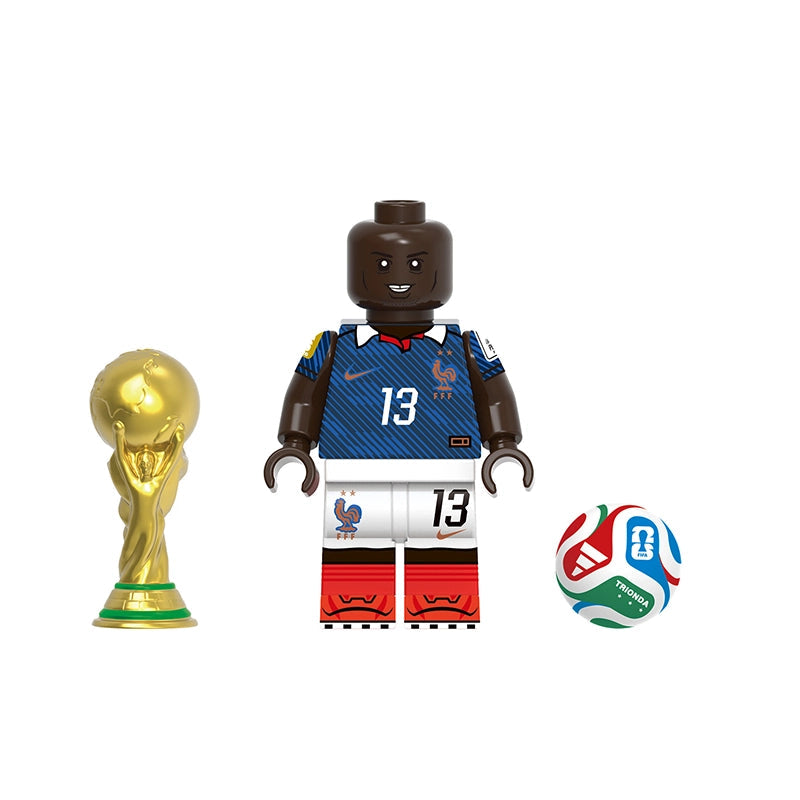 A soccer-themed toy set featuring a minifigure named Kanté wearing a blue and white France jersey with the number 13, a gold FIFA trophy, and a multicolor soccer ball. The image has a gray label at the top reading 'GHO834' and the name 'Kanté' below the figure.