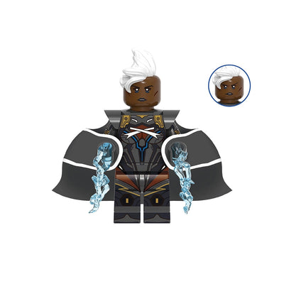 A custom block-style minifigure of Storm from Marvel, featuring dark skin, white hair, a black and gray cape, and blue energy effects on her arms, shown on a plain white background with a model number 'GHO969' at the top.